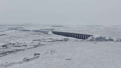 Wide-Angle-Establishing-Aerial-Drone-Shot-of-Ribblehead-Viaduct-on-Snowy-and-Gloomy-Day-in-Yorkshire-Dales-UK