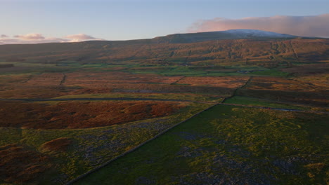 Establishing-Aerial-Drone-Shot-of-Snowy-Whernside-Mountain-at-Golden-Hour-Sunset-in-Yorkshire-Dales-UK