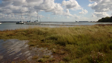 Wide-shot-of-low-lying-grass-flooded-at-high-tide-taken-at-Ashlett-creek-sailing-club-in-the-Solent,-Southampton