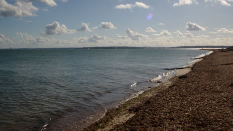 shot-of-the-shingle-beach-looking-towards-the-Isle-of-Wight-at-Calshot-spit-by-the-Solent,-Southampton