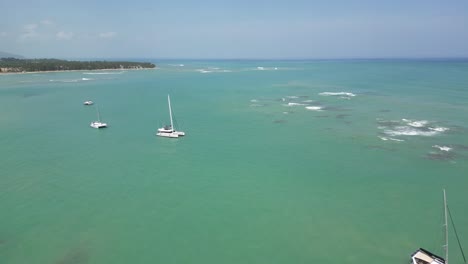 Luxurious-boats-in-the-turquoise-waters-near-the-beach-of-Punta-Popy-in-the-tourist-town-Las-Terrenas-in-the-Dominican-Republic