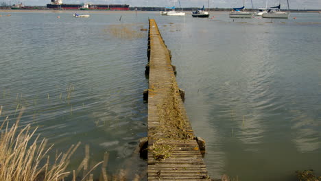 mid-shot-of-a-long-wooden-jetty-with-flooding-debris-on-top