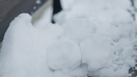 Slowmotion-closeup-of-grabing-and-removing-pile-of-snowballs-with-black-gloves