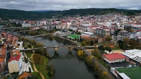 Bridge-crossing-Miño-River-connecting-vibrant-city-of-Ourense,-grey-cloudy-sky