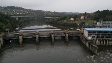 Frontale-Weitwinkelansicht-Des-Velle-Staudamms-Und-Des-Kraftwerks-In-Ourense,-Galicien,-Spanien-Und-Brückenreflexion