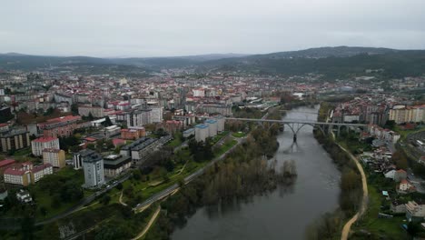 Panoramic-aerial-establishing-view-of-Ourense-in-galicia,-spain-uner-dark-grey-winter-skies