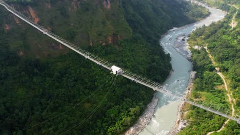 Kushma-bungee-jumping-off-suspension-bridge-high-above-ravine