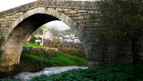Historische-Steinbrücke-Mit-Einzigartigem-Gewölbtem-Mauerwerk,-Während-Unten-Wasser-Vom-Fluss-Lonia-Fließt