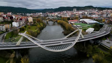 Millennium-Bridge-Miño-River-in-Ourense,-Galicia,-Spain-with-Roman-bridge-behind