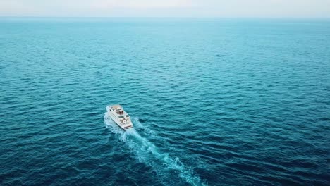 Drone-shot-of-yacht-sailing-to-the-horizon-in-the-Sea-of-Cortez,-Mexico