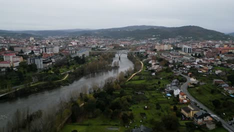 Un-Dron-Se-Eleva-A-Lo-Largo-Del-Río-Miño-Para-Establecer-Una-Metrópolis-Urbana-En-Ourense,-España