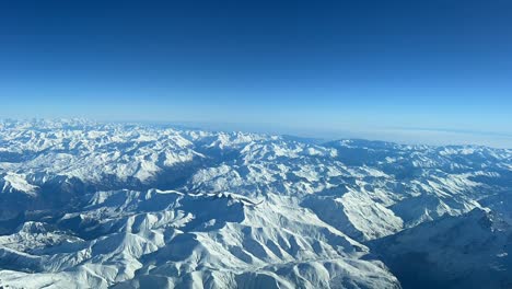 Hyperlapse-view-of-the-Alps-snowed-mountains-during-a-flight-with-turbulence,-as-seen-by-the-pilots-in-a-real-flight