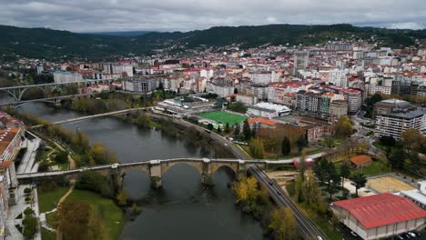 Angled-overview-of-brdiges-crossing-river-with-Ourense-Roman-Bridge-on-Miño-River-in-Ourense,-Galicia,-Spain