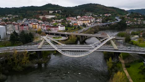 Recorrido-Lento-De-Camiones-Alrededor-De-La-Arquitectura-Curva-única-Del-Puente-Del-Milenio-Sobre-El-Río-Miño-En-Ourense,-Galicia,-España