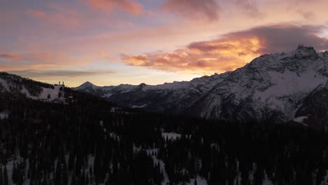 Winter-season-in-Valmalenco-of-Valtellina-at-sunset,-aerial-drone-backward-view