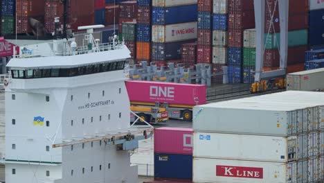 Automated-container-vehicles-passing-each-other-at-the-background-of-a-cargo-ship