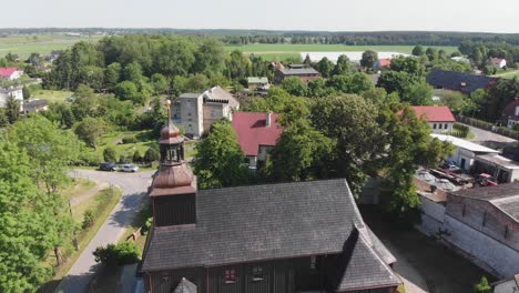 Schwarze-Holzkirche-Mit-Dunklem-Glockenturm-Und-Goldenem-Kugelturm-In-Einem-Ländlichen-Dorf