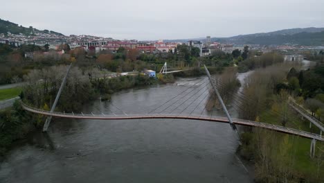 Sinuoso-Puente-Peatonal-Curvo-Cruza-El-Río-Miño-En-Oira,-Ourense,-España