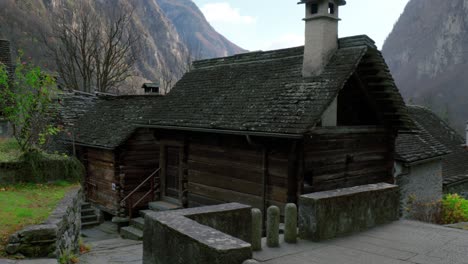 Wooden-houses-with-stone-chimneys-are-meeting-the-first-snow-in-the-mountain-village-of-Cavergno,-Switzerland