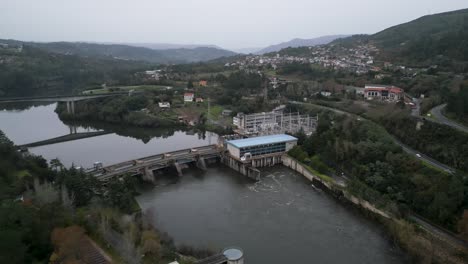 Empuje-En-ángulo-Con-Drones-Hacia-El-Agua-Que-Fluye-Desde-La-Presa-De-Velle-Y-La-Central-Eléctrica-En-Ourense,-Galicia,-España