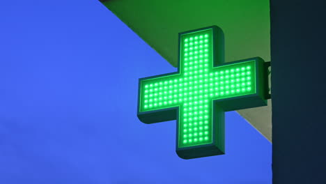 Pharmacy-store-green-cross-blinking-at-night
