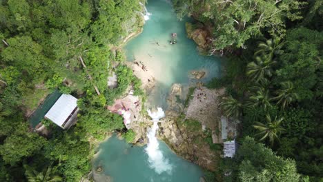 People-arriving-End-point-of-kawasan-falls-Canyoneering-at-blue-plunge-pools-amid-green-tropical-forest