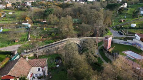 Drohne-Umkreist-Die-Dreieckige-Brücke-Des-Flusses-Lonia-Mit-Großer,-Breiter-Öffnung-In-Ourense,-Spanien