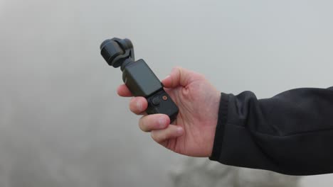Close-up-of-DJI-Osmo-Pocket-3-stabilized-handheld-mobile-camera-outdoors
