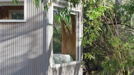 Filmischer-Blick-Auf-Das-Winzige-Schlafzimmerfenster-Einer-Hütte-Mit-Blick-Auf-Den-Wald