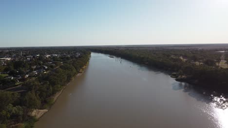 Aerial-view-of-a-brown-river-in-Australia-small-country-town-on-the-left-side