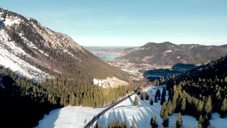 Impresionante-Vista-Aérea-De-Drones:-Paso-De-Montaña-Cubierto-De-Nieve,-Vista-Panorámica-De-Schliersee-En-Alemania,-Paisaje-De-Los-Alpes-Bávaros-Con-Carretera-Y-Lago-De-Montaña-Distante-En-La-Temporada-De-Invierno