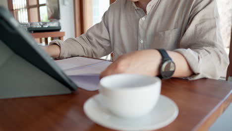 Close-up-of-Asian-man-turns-over-the-notebook-pages-in-a-cafe