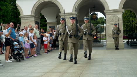 Guardias-Uniformados-En-Una-Tumba-Ceremonial-Del-Soldado-Desconocido,-Marchan-Junto-A-La-Llama-Eterna-En-Un-Monumento-Conmemorativo-De-Varsovia---Plaza-Piłsudski