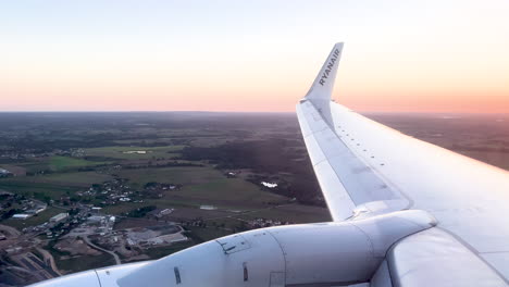 Ein-Flugzeugflügel-Mit-Firmenlogo-Ist-In-Die-Sanften-Dämmerungstöne-Des-Abendhimmels-Getaucht-–-Ryanair-Line
