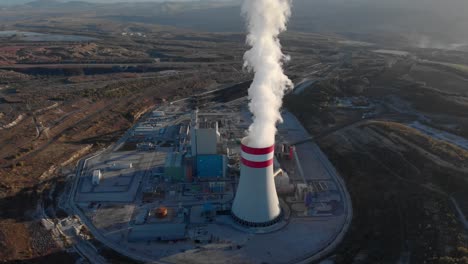 Aerial-view-Smoke-from-a-coal-fired-power-plant-chimney-Tilt-down-Sunset