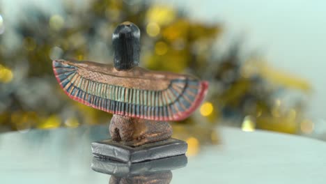 Dreamy-close-up-shot-of-a-Cleopatra-statue-with-wide-open-wings,-shiny-golden-depth-of-field,-ancient,-Egyptian-historical-ruler,-antique-artwork-of-a-goddess,-rotating-360-cinematic-static-4K-video