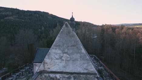 An-aerial-view-from-the-back-of-a-flying-camera-reveals-the-terrifying-face-of-a-girl-on-the-plaster-of-a-gothic-church-in-Velhartice