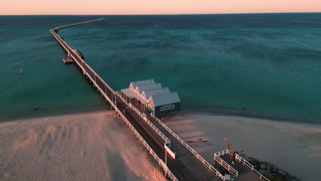 drone-shot-around-the-Busselton-Jetty-in-Western-Australia-at-sunset-with-the-beach-in-the-foreground-and-the-indian-ocean-in-the-background