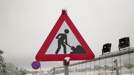 Traffic-sign-construction,-on-a-winter-day,-with-cloudy-and-foggy-sky-in-the-background