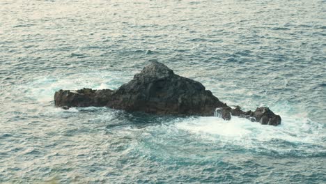 Cinematic-slow-motion-shot-of-offshore-volcanic-rock-in-Tenerife,-foaming-waves