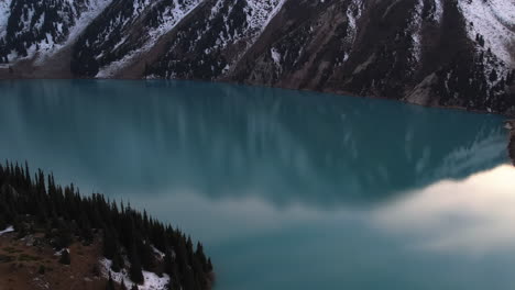 Drone-circling-over-the-reflecting-surface-of-the-Big-Almaty-Lake,-in-Kazakhstan
