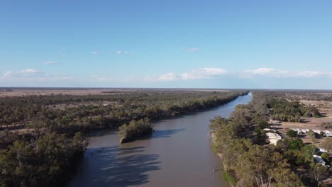 Drone-Cruzando-Un-Río-Mostrando-Una-Pequeña-Isla-Y-Un-Pueblo