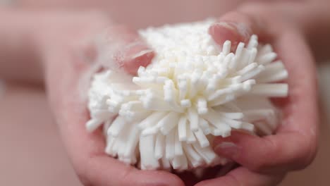 Woman-holding-foamy-loofah-in-hands,-close-up