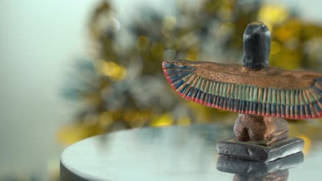 Dreamy-close-up-shot-of-a-Cleopatra-statue-with-wide-open-wings,-hazy-golden-depth-of-field,-ancient,-Egyptian-historical-ruler,-antique-artwork-of-a-goddess,-rotating-360-smooth-4K-video-pan-right