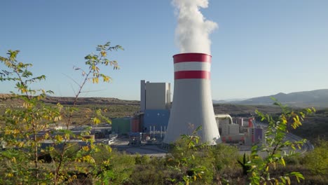 Coal-fired-power-station-plant-cooling-towers-emitting-Smoke-Steam-sunny-day
