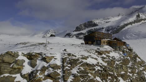 Drohne-Nähert-Sich-Dem-Rifugio-Quintino-Sella-Al-Felik-Mit-Dem-Castore-Gipfel-Und-Dem-Gletscher-Im-Hintergrund