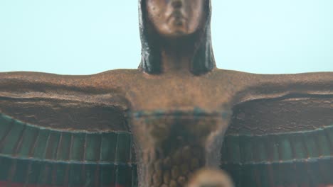 Dreamy-macro-shot-of-a-Cleopatra-statue-with-wide-open-wings,-hazy-depth-of-field,-ancient-Egypt-Queen-of-Kings,-Egyptian-dynasty-historical-ruler,-antique-artwork-of-a-goddess,-4K-video-tilt-up