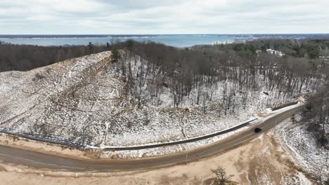 Large-dunes-lining-the-coast-of-lake-Michigan,-approaching-during-small-winter-flurry