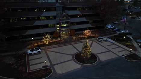 Aerial-approaching-shot-of-business-building-in-Greenfield-Lancaster-with-decorated-Lighting-trees-at-dusk