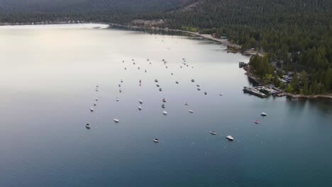 A-high-flying,-4K-drone-shot-over-anchored-boats-during-a-summertime-sunset,-off-the-coast-of-Lake-Tahoe,-California